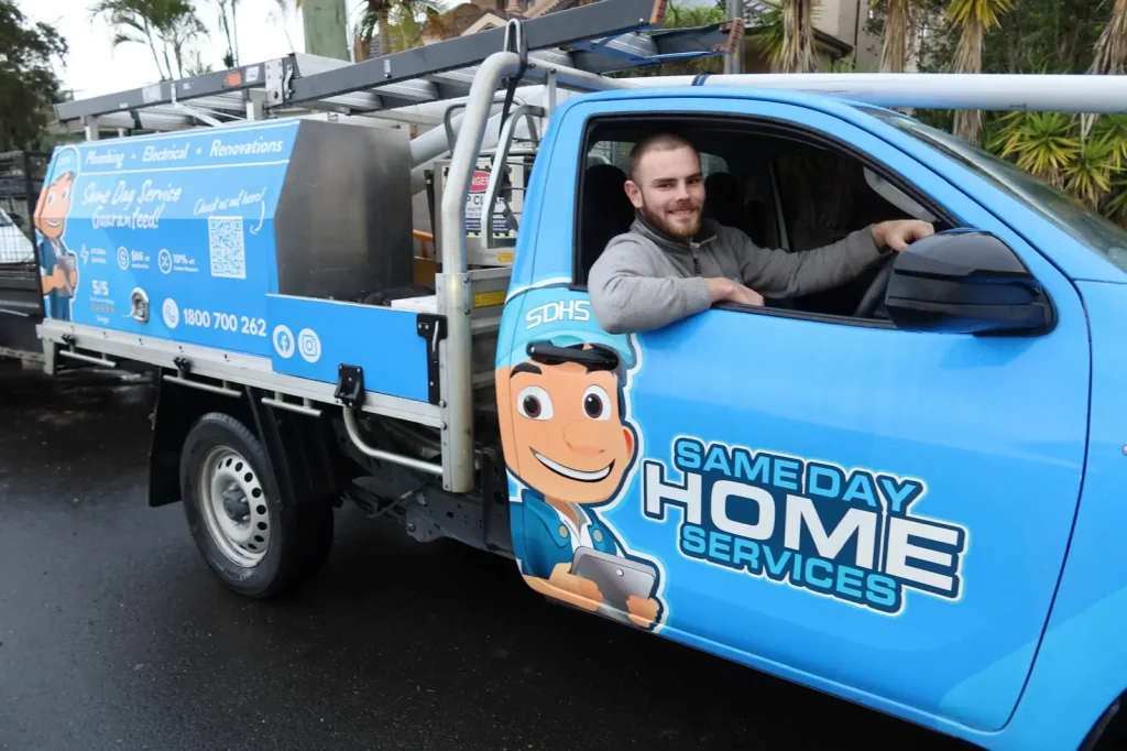 Same Day Home Services team member in a branded plumbing vehicle
