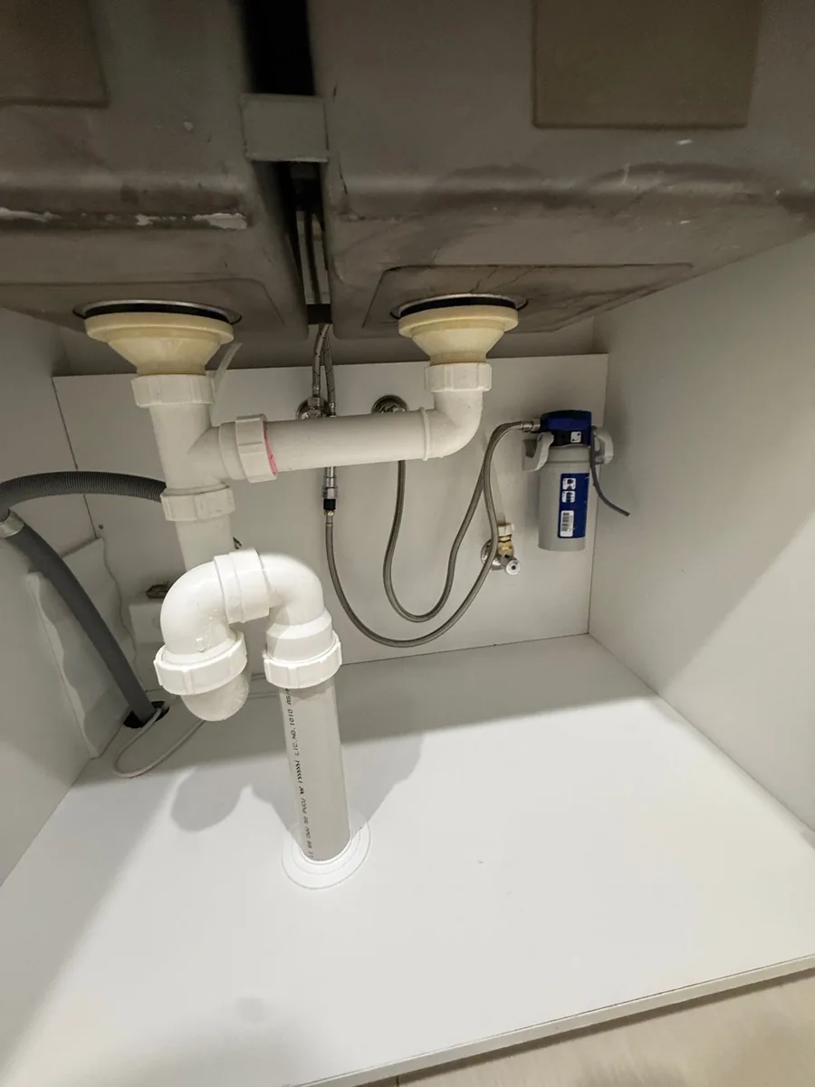 Kitchen cupboard showing the fitted filter and waste pipework