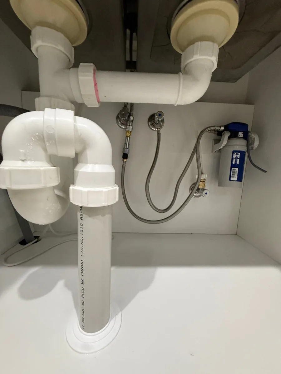 Under-sink plumbing and water filter at a Parramatta apartment